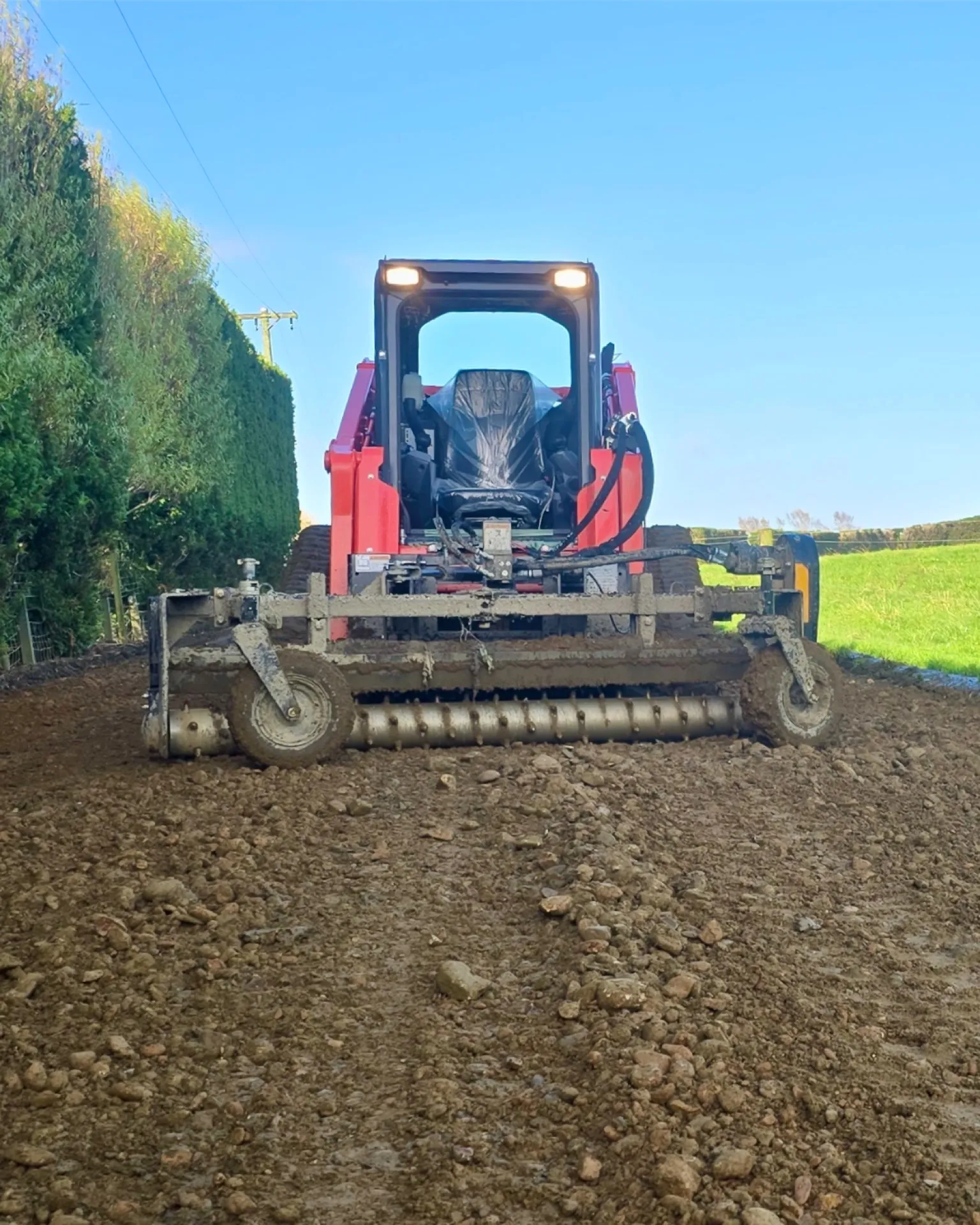 Power rake attachment levelling fresh gravel on a Southland farm track